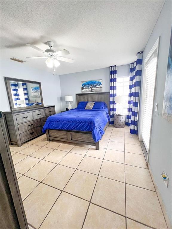 307 Diamond Ridge Boulevard Auburndale, FL 33823 - Photo 17 of 31 a spacious bedroom with a bed and a chandelier
