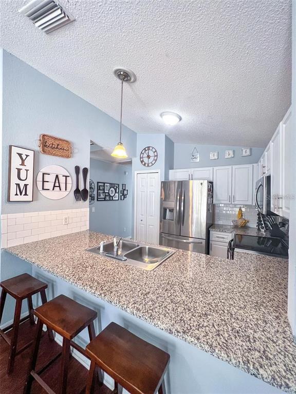 307 Diamond Ridge Boulevard Auburndale, FL 33823 - Photo 9 of 31 a kitchen with stainless steel appliances granite countertop a sink and a refrigerator
