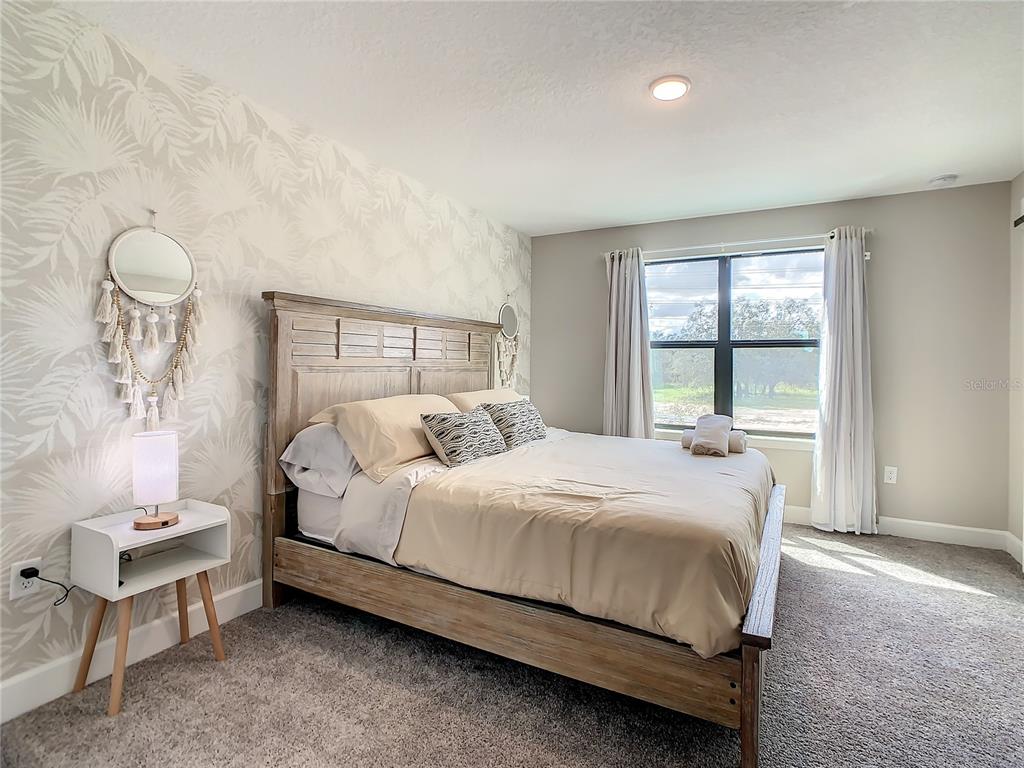 208 Villa Domani Circle Davenport, FL 33896 - Photo 16 of 26 a bedroom with a bed and a window