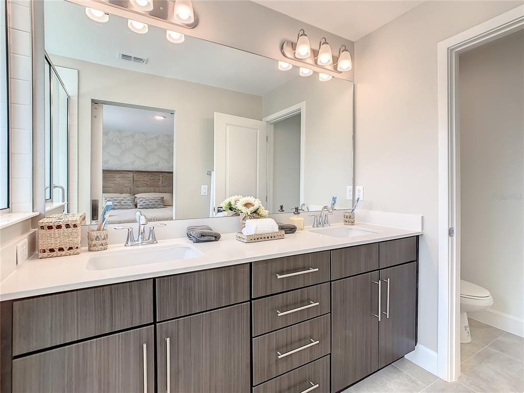 208 Villa Domani Circle Davenport, FL 33896 - Photo 19 of 26 a bathroom with a double vanity sink mirror and toilet