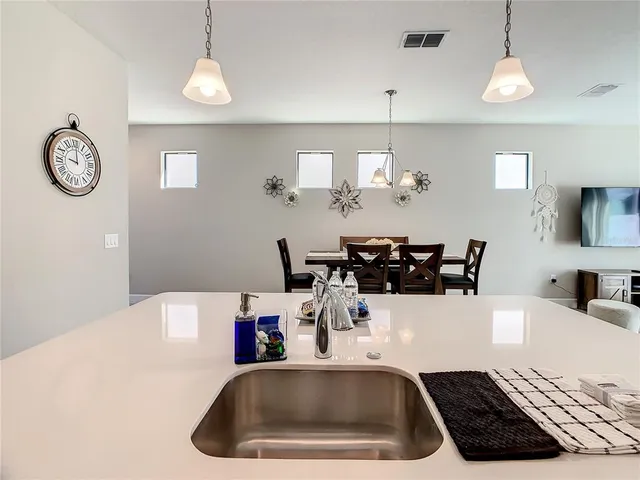a kitchen with a refrigerator a sink and a table