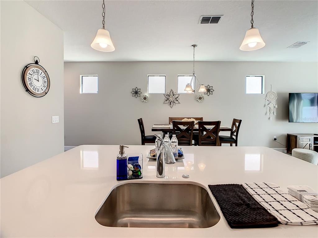 208 Villa Domani Circle Davenport, FL 33896 - Photo 5 of 26 a kitchen with a refrigerator a sink and a table