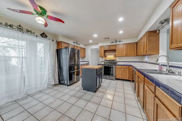 a kitchen with granite countertop a sink a counter top space and cabinets