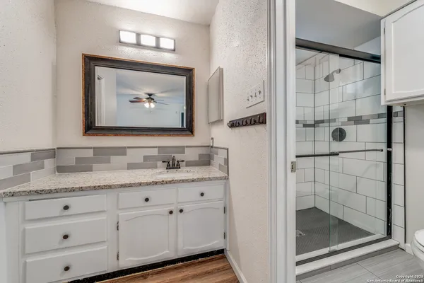 a bathroom with a granite countertop toilet a sink and a mirror