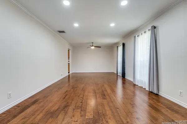 a view of an empty room with window and fire place