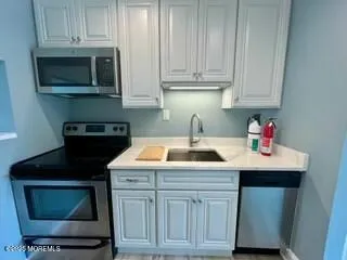 a kitchen with stainless steel appliances granite countertop a sink stove and microwave