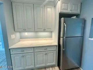 a kitchen with granite countertop cabinets and refrigerator