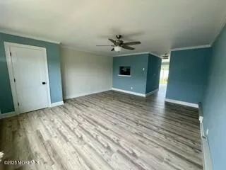 a view of empty room with wooden floor and a ceiling fan