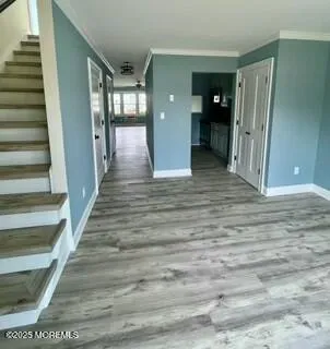a view of a hallway with wooden floor and entryway