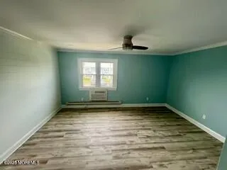 a view of a room with window a ceiling fan and wooden floor