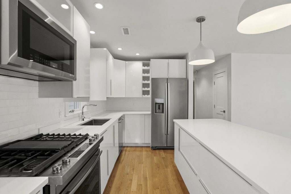 14 Hardwick Street, Unit 1 Cambridge, MA 02141 - Photo 11 of 31 a kitchen with stainless steel appliances kitchen island granite countertop a stove and a refrigerator