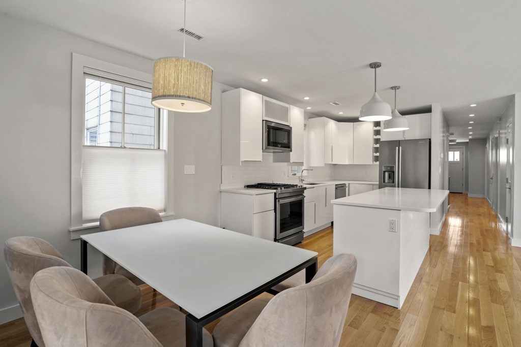 14 Hardwick Street, Unit 1 Cambridge, MA 02141 - Photo 13 of 31 a kitchen with stainless steel appliances kitchen island granite countertop a table chairs and a refrigerator