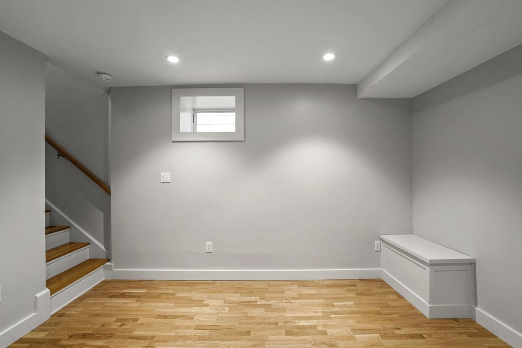14 Hardwick Street, Unit 1 Cambridge, MA 02141 - Photo 26 of 31 a view of an empty room with wooden floor and stairs