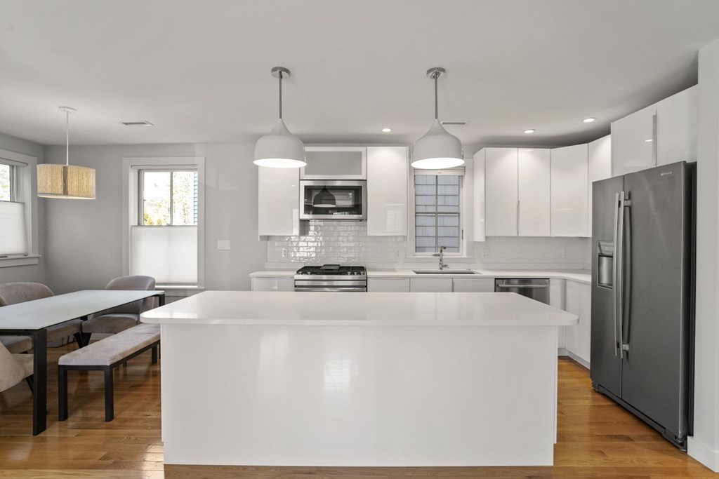 14 Hardwick Street, Unit 1 Cambridge, MA 02141 - Photo 9 of 31 a kitchen with kitchen island a stove a sink a refrigerator a center island a stove and a center island