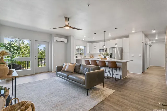 a living room with furniture kitchen view and a large window