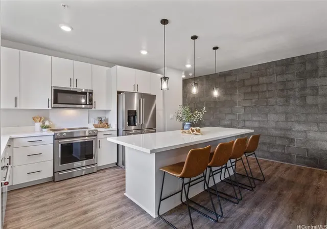 a kitchen with a table chairs microwave and cabinets