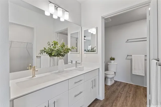a bathroom with a sink a toilet and a large mirror