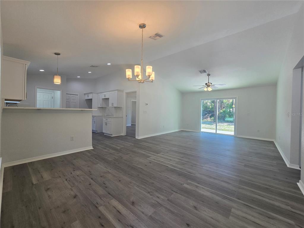 131 Fisher Road Ocklawaha, FL 32179 - Photo 15 of 42 an empty room with wooden floor and windows