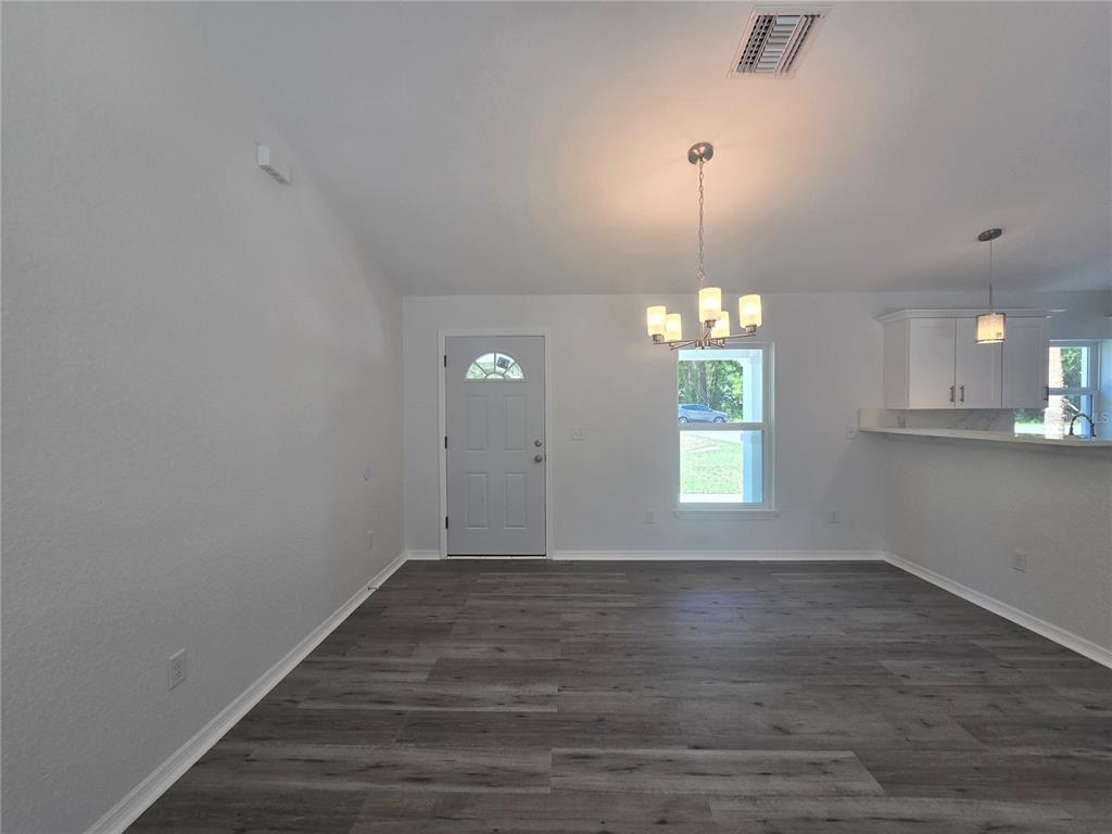 131 Fisher Road Ocklawaha, FL 32179 - Photo 16 of 42 a view of an empty room with window and wooden floor