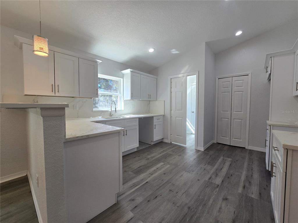 131 Fisher Road Ocklawaha, FL 32179 - Photo 16 of 41 a kitchen with a refrigerator sink and cabinets