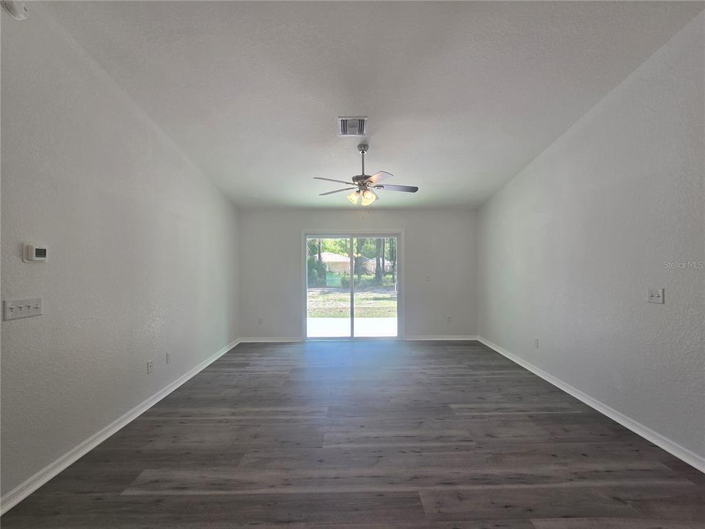 131 Fisher Road Ocklawaha, FL 32179 - Photo 17 of 42 wooden floor in an empty room with a window