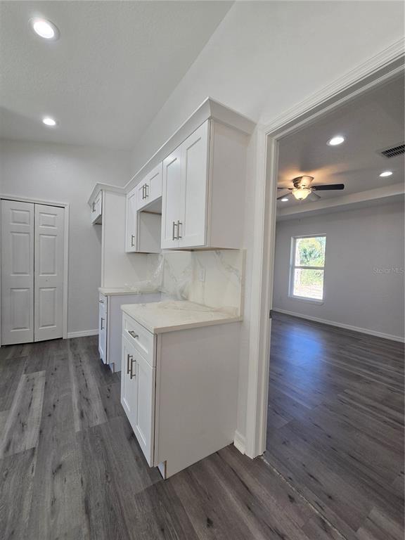 131 Fisher Road Ocklawaha, FL 32179 - Photo 18 of 41 a kitchen with hard wood floors and white cabinets