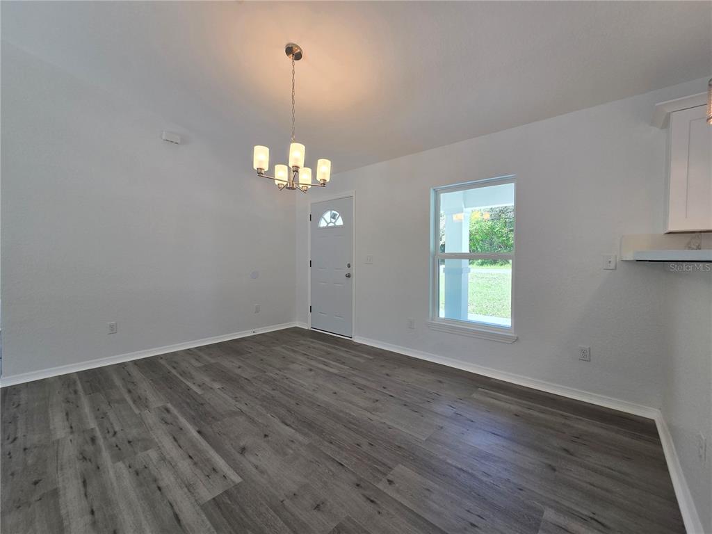 131 Fisher Road Ocklawaha, FL 32179 - Photo 18 of 42 an empty room with wooden floor and windows