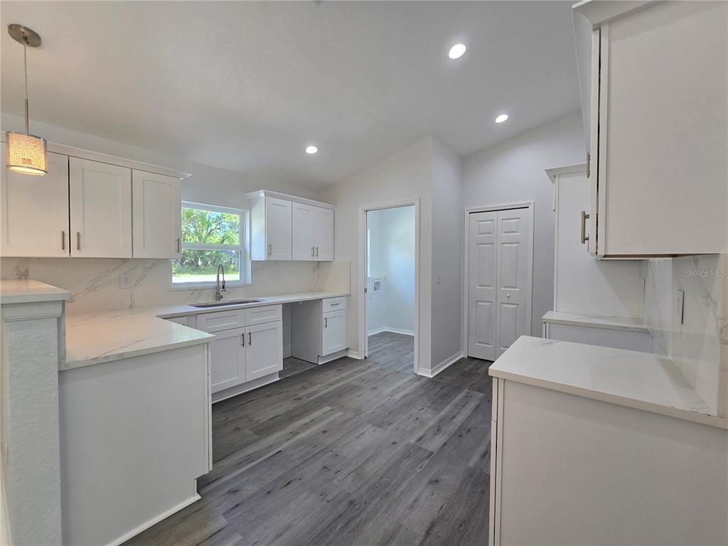 131 Fisher Road Ocklawaha, FL 32179 - Photo 19 of 42 a kitchen with a sink cabinets stainless steel appliances and a window