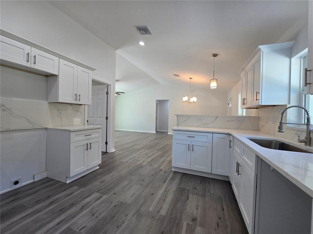 131 Fisher Road Ocklawaha, FL 32179 - Photo 20 of 42 a kitchen with sink cabinets and wooden floor