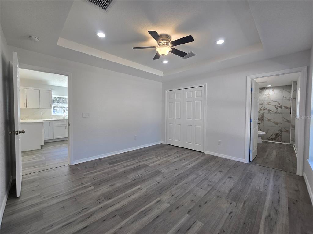 131 Fisher Road Ocklawaha, FL 32179 - Photo 20 of 41 a view of a livingroom with wooden floor and a ceiling fan