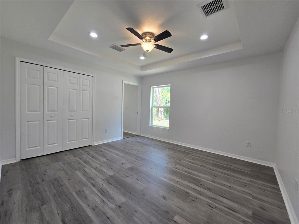 131 Fisher Road Ocklawaha, FL 32179 - Photo 23 of 42 a view of an empty room with wooden floor and a ceiling fan