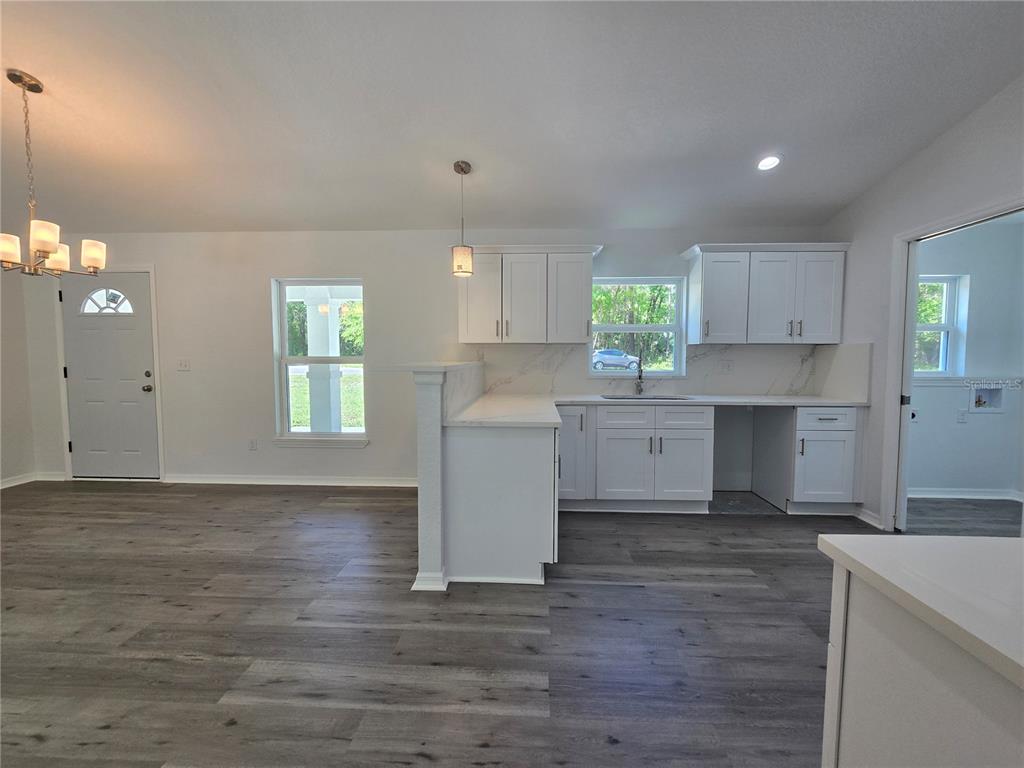 131 Fisher Road Ocklawaha, FL 32179 - Photo 28 of 42 a kitchen with granite countertop a stove a sink and a microwave