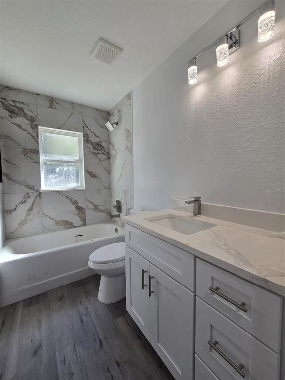 131 Fisher Road Ocklawaha, FL 32179 - Photo 32 of 41 a bathroom with a granite countertop toilet a sink and bathtub