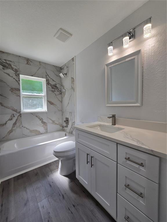 131 Fisher Road Ocklawaha, FL 32179 - Photo 33 of 42 a bathroom with a toilet a sink a tub and a mirror