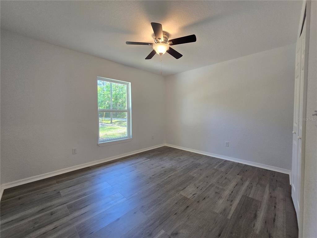131 Fisher Road Ocklawaha, FL 32179 - Photo 35 of 42 a view of empty room with wooden floor and fan