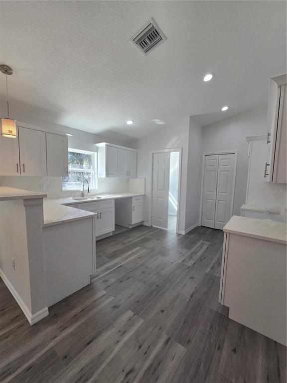 131 Fisher Road Ocklawaha, FL 32179 - Photo 36 of 41 a kitchen with a sink wooden floor and white cabinets