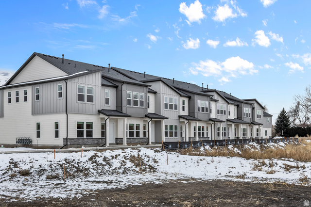 3014 South 265th Street West Logan, UT 84321 - Photo 2 of 25 Contemporary townhome exteriors featuring white siding, vertical gray paneling, dark roofs, and stone accents