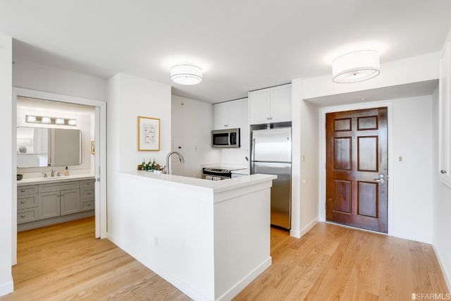 a kitchen with stainless steel appliances granite countertop a refrigerator and a stove top oven