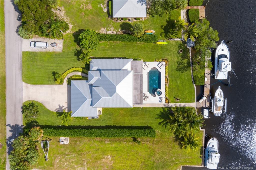 5854 Southeast Horseshoe Point Road Stuart, FL 34997 - Photo 13 of 56 an aerial view of a house with a garden potted plants and large trees