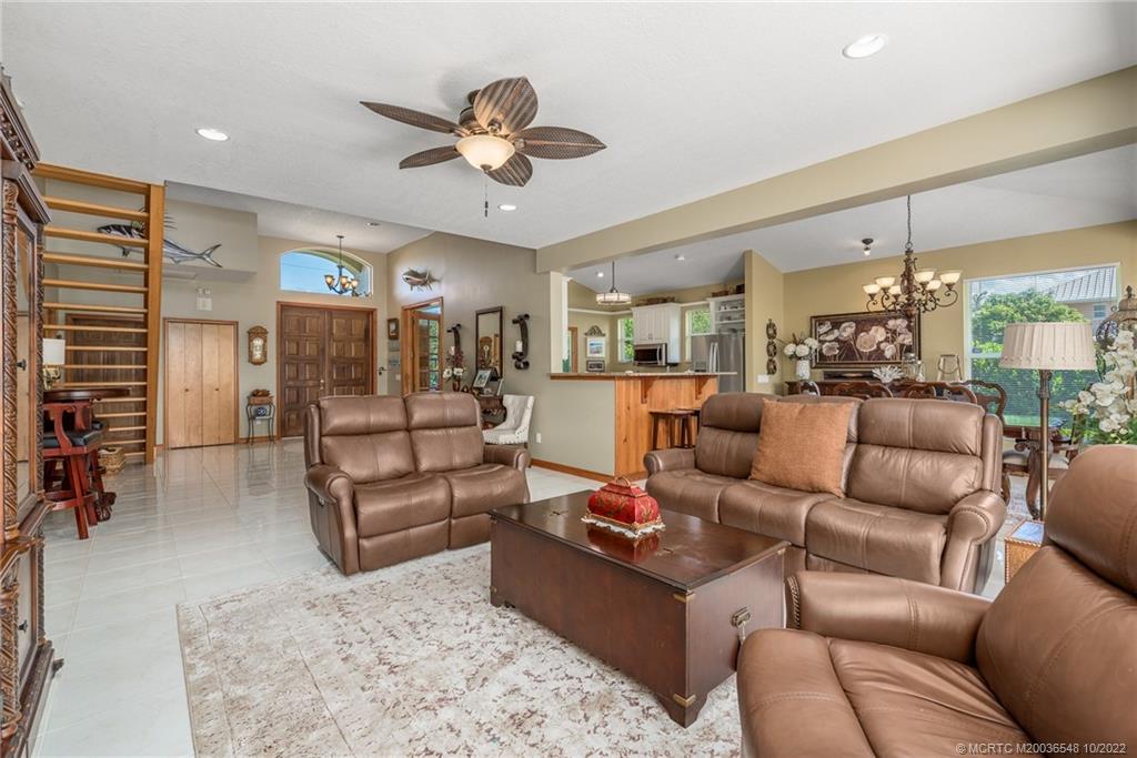 5854 Southeast Horseshoe Point Road Stuart, FL 34997 - Photo 16 of 56 a living room with furniture ceiling fan and a rug