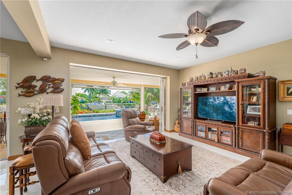 5854 Southeast Horseshoe Point Road Stuart, FL 34997 - Photo 18 of 56 a living room with furniture a flat screen tv and a large window
