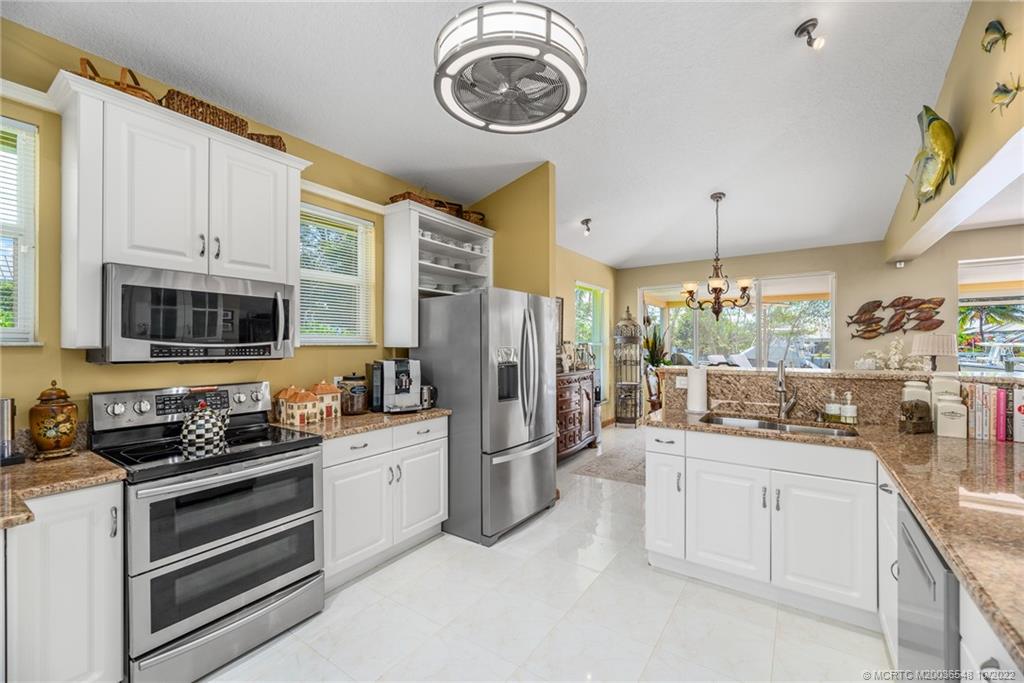 5854 Southeast Horseshoe Point Road Stuart, FL 34997 - Photo 21 of 56 a kitchen with white cabinets and appliances