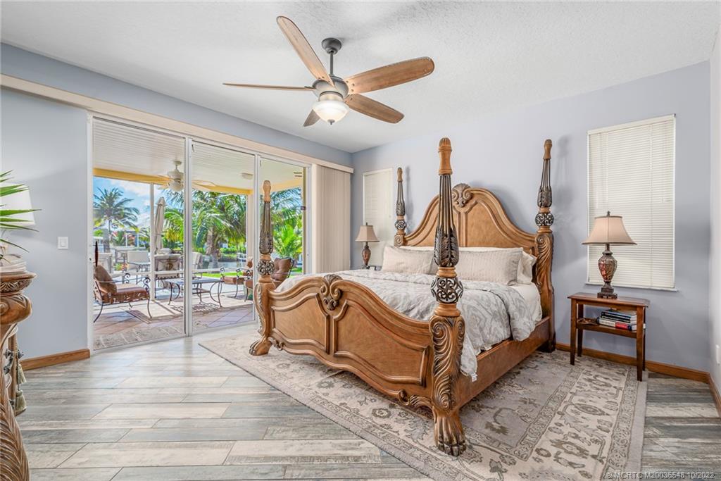 5854 Southeast Horseshoe Point Road Stuart, FL 34997 - Photo 27 of 56 a bed sitting in a spacious bedroom next to a window