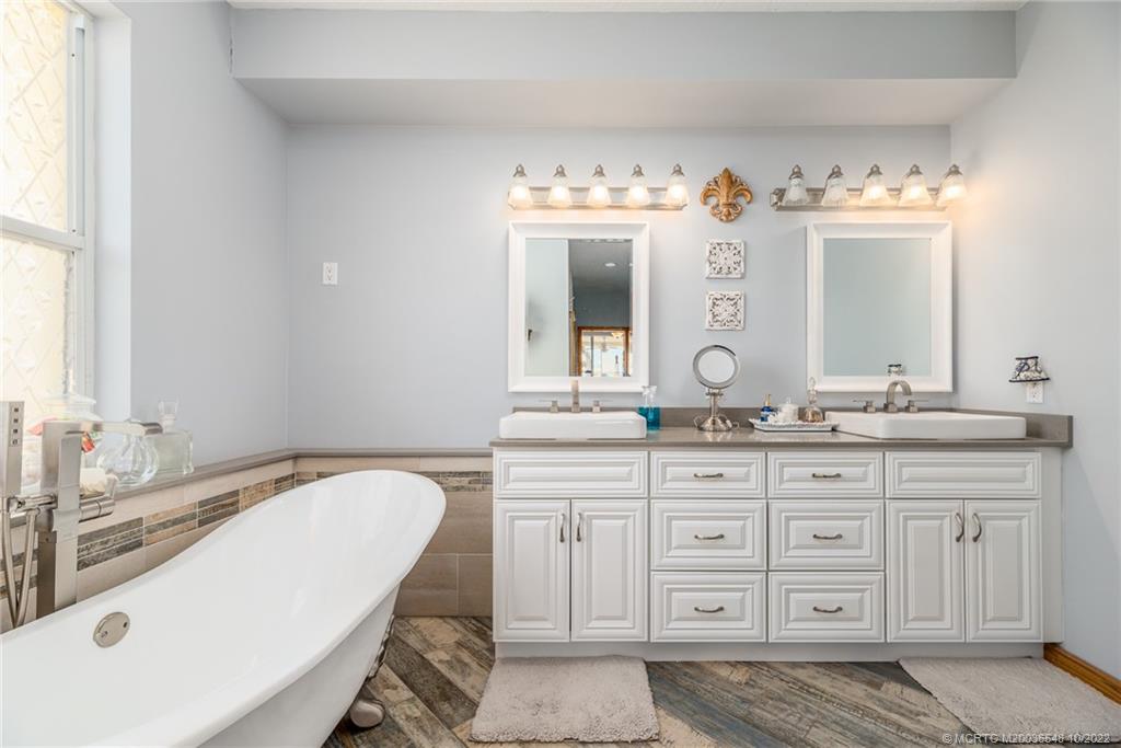 5854 Southeast Horseshoe Point Road Stuart, FL 34997 - Photo 30 of 56 a spacious bathroom with a granite countertop sink mirror and a bathtub