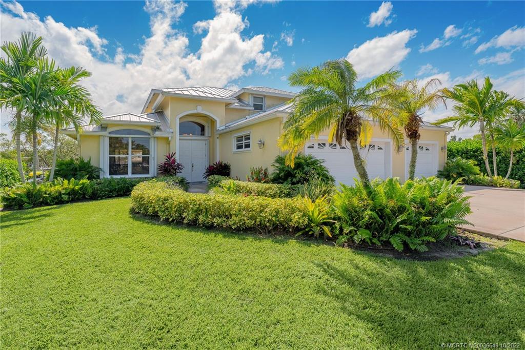 5854 Southeast Horseshoe Point Road Stuart, FL 34997 - Photo 3 of 56 a front view of a house with a garden
