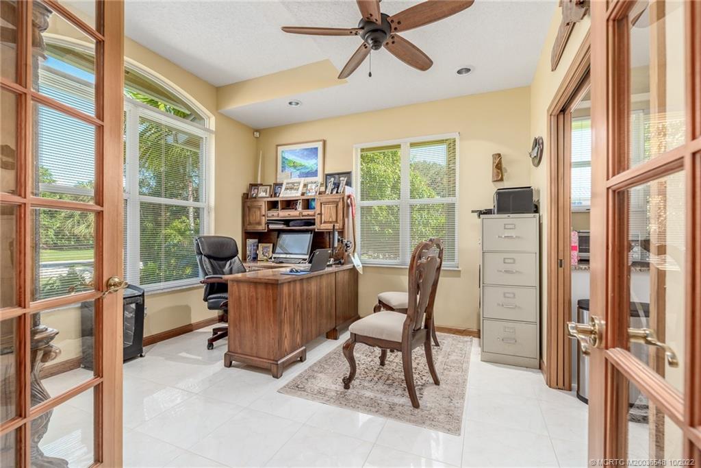 5854 Southeast Horseshoe Point Road Stuart, FL 34997 - Photo 32 of 56 a dining room with furniture a flat screen tv and a floor to ceiling window