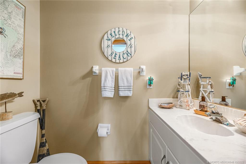 5854 Southeast Horseshoe Point Road Stuart, FL 34997 - Photo 33 of 56 a bathroom with a sink mirror vanity and toilet