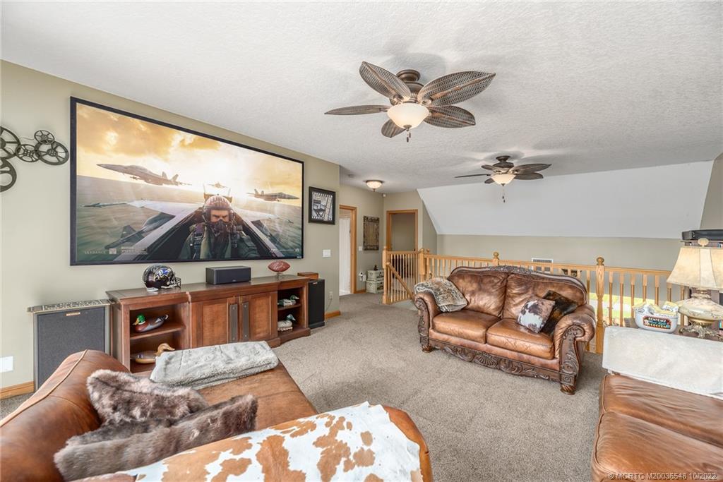 5854 Southeast Horseshoe Point Road Stuart, FL 34997 - Photo 35 of 56 a living room with furniture a flat screen tv and a large window