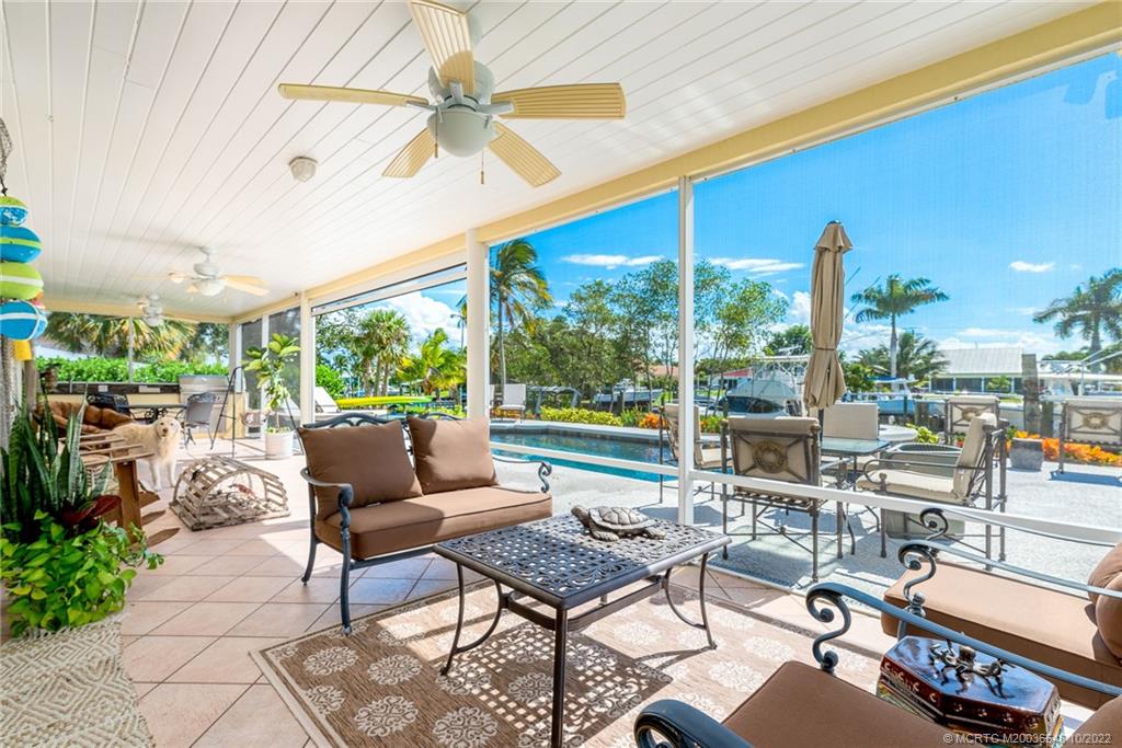 5854 Southeast Horseshoe Point Road Stuart, FL 34997 - Photo 41 of 56 a living room with patio furniture and a floor to ceiling window
