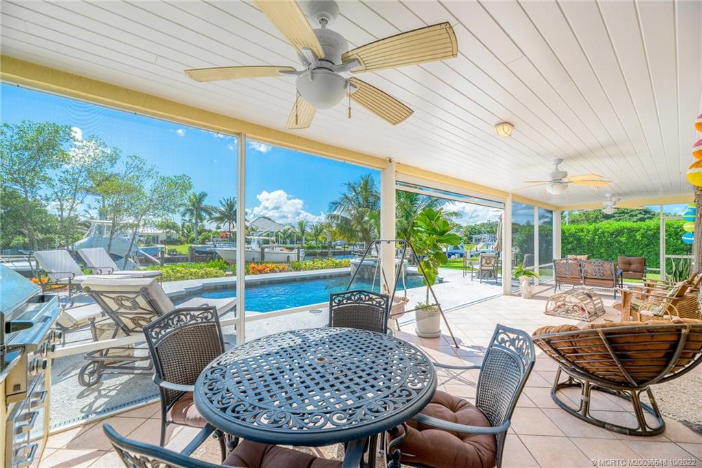 5854 Southeast Horseshoe Point Road Stuart, FL 34997 - Photo 42 of 56 a view of a patio with a dining table and chairs